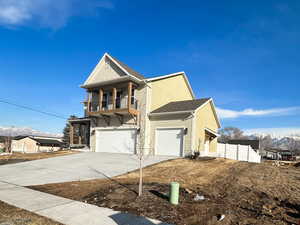 View of front of home with a mountain view, a balcony, a shingled roof, and concrete driveway