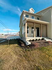 View of front of property with covered porch and a front lawn