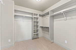 Walk in closet featuring light colored carpet