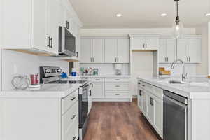 Kitchen featuring stainless steel appliances, light stone counters, dark wood-style flooring, tasteful backsplash, and recessed lighting