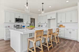 Kitchen with tasteful backsplash, white cabinetry, stainless steel appliances, and recessed lighting