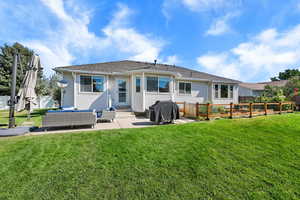 Rear view of property featuring an outdoor hangout area, a yard, a patio, and roof with shingles