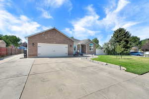 Single story home with brick siding, concrete driveway, and an attached garage and RV parking
