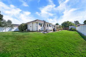 Rear view of house featuring a fenced backyard, a patio, and an outdoor living space