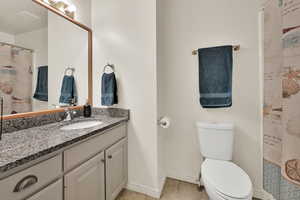 Full bathroom with vanity, light tile patterned floors, and a tub/shower combo with granite counter