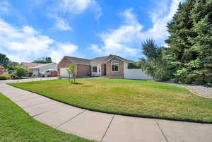 Single story home featuring brick siding, driveway, and an attached garage