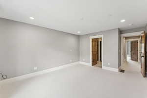 Spare room featuring light colored carpet and recessed lighting