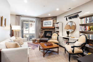 Sitting room with a stone fireplace and recessed lighting