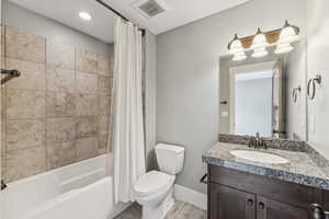 Full bath featuring vanity, shower / tub combo, and light tile patterned floors