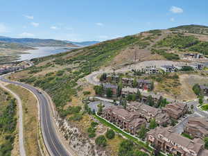 Aerial view of property's location with a water and mountain view and nearby suburban area