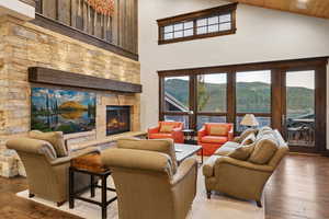 Living room with a fireplace, hardwood / wood-style floors, high vaulted ceiling, and wood ceiling