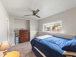 Carpeted bedroom featuring a ceiling fan and baseboards