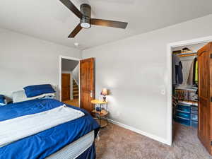 Carpeted bedroom with baseboards and a ceiling fan