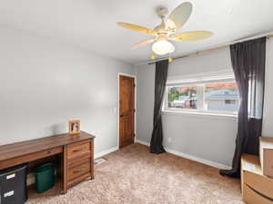 Office space featuring light colored carpet and ceiling fan