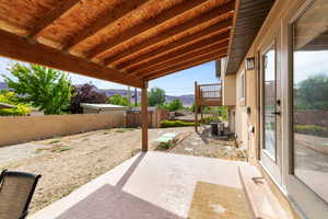 Fenced backyard featuring a storage unit, a Moab Rim view, and a patio