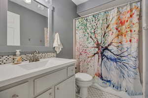 Full bathroom with vanity, decorative backsplash, shower / bath combo