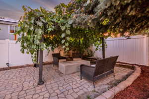 Fenced backyard featuring a patio area and an outdoor living space with a fire pit