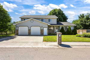 Traditional home featuring driveway, a garage, stucco siding, and brick siding