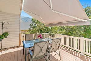 Deck with outdoor dining area and a mountain view