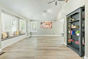 Interior space featuring light wood finished floors, vaulted ceiling, and ceiling fan