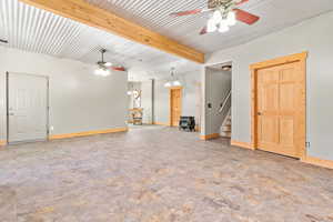 Unfurnished living room with beam ceiling, stairway, and ceiling fan