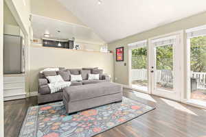 Living room featuring wood finished floors and high vaulted ceiling