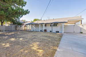 View of front of house with a gate, a patio area, and a carport
