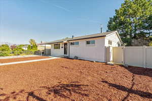 Rear view of house featuring a fenced backyard and brick siding