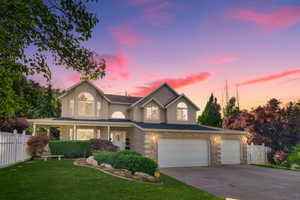 Traditional-style house with concrete driveway, stucco siding, a porch, and a garage