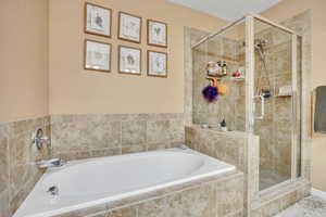 Owner's suite, full bathroom with a shower stall and a garden tub