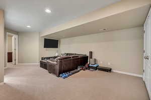 Home theater with light carpet and recessed lighting