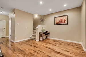 Main level with light wood finished floors, recessed lighting, and stairway