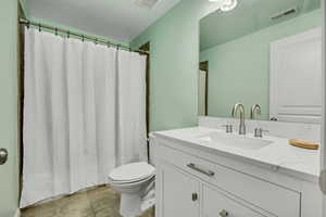 Full bath featuring vanity, curtained shower, and light tile patterned floors