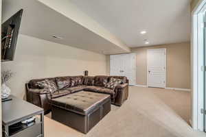 Living room with light colored carpet and recessed lighting
