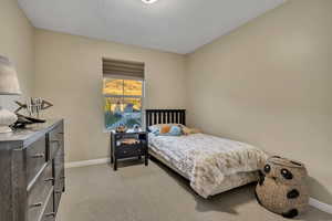 Bedroom with light carpet and a textured ceiling