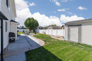 Fenced backyard with a patio and a shed