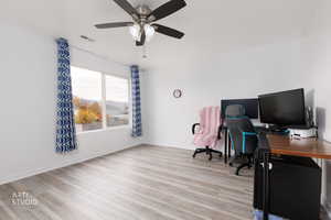 Home office with light wood-type flooring and a ceiling fan