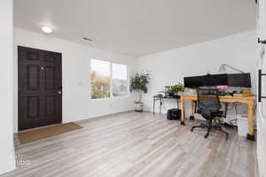 Office area with light wood-style flooring and baseboards
