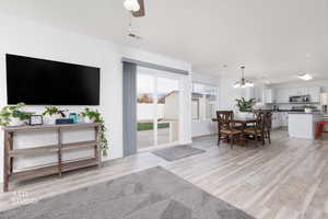 Living area with light wood-style flooring and a chandelier