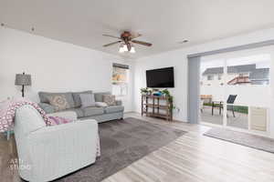 Living room with wood finished floors and a ceiling fan