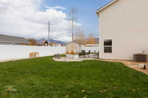 Fenced backyard with a patio, a mountain view, and an outbuilding