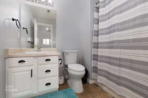 Bathroom with vanity, curtained shower, and dark tile patterned floors