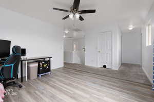 Office space with light wood-style floors and ceiling fan