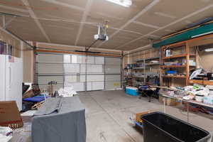 Garage with freestanding refrigerator and a garage door opener