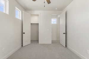 Unfurnished bedroom with light carpet, a closet, and a ceiling fan
