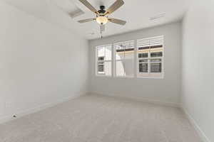 Spare room featuring light carpet and a ceiling fan