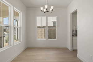 Unfurnished dining area featuring light wood-style floors and a chandelier