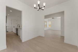 Unfurnished dining area featuring a chandelier, light wood-style floors, and recessed lighting