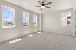 Spare room featuring light carpet and a ceiling fan
