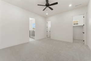Unfurnished bedroom with light carpet, recessed lighting, a ceiling fan, and ensuite bathroom